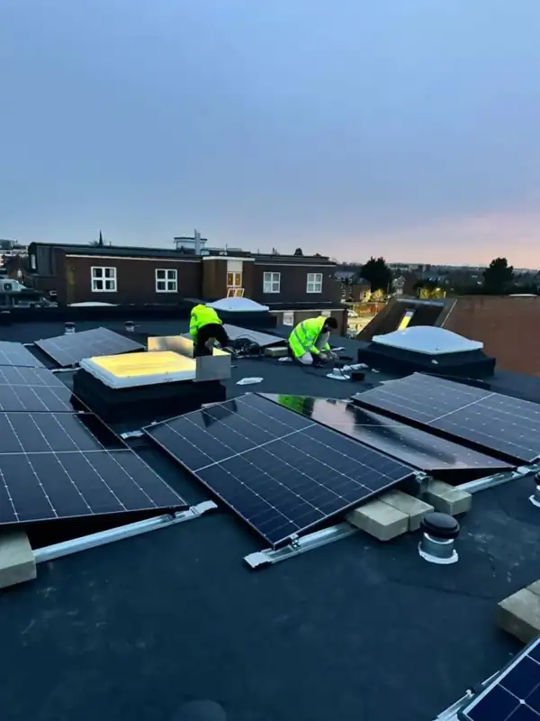 Installers working beside solar panels on a flat roof