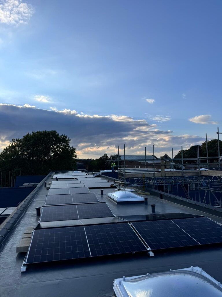Completed solar panel array at sunset on a flat roof