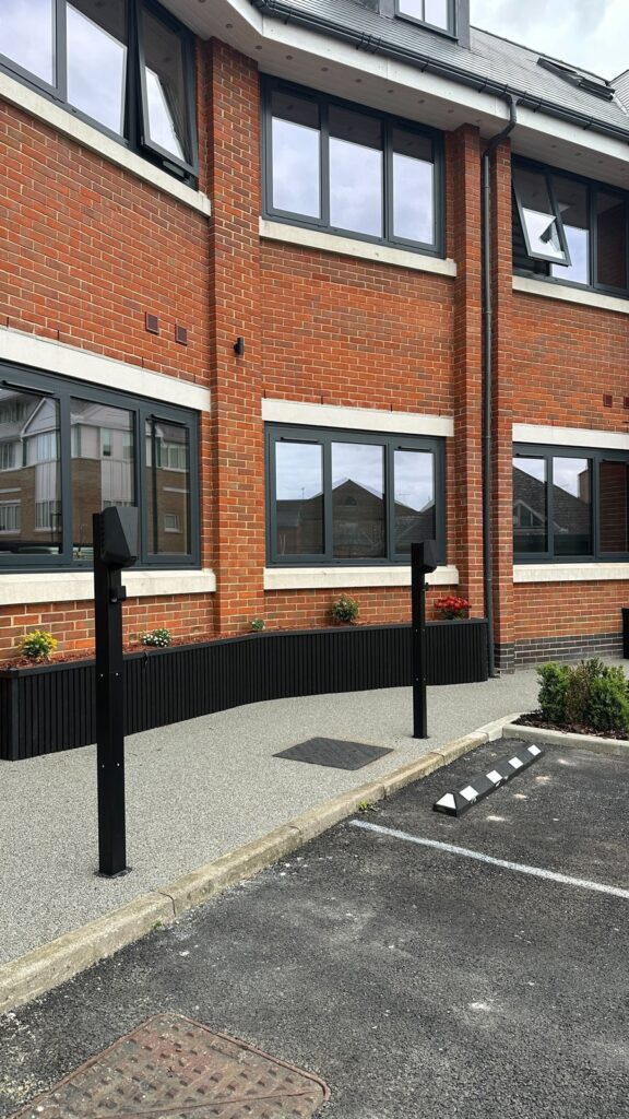 Two post-mounted EV chargers along the front of the block